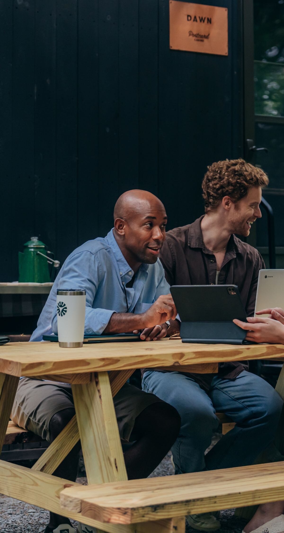 Group Working at Picnic Table in Front of Cabin