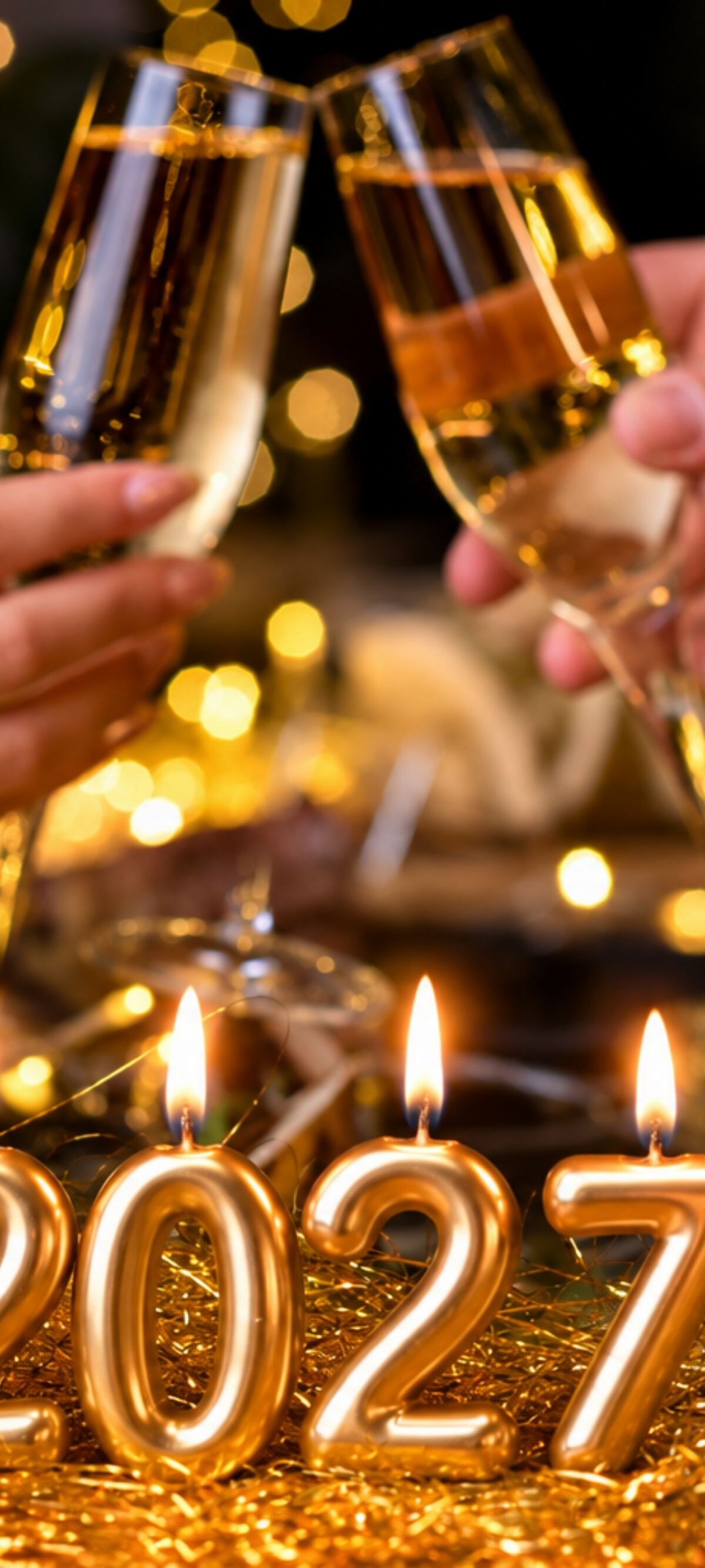 Two people toast beside 2027 candles
