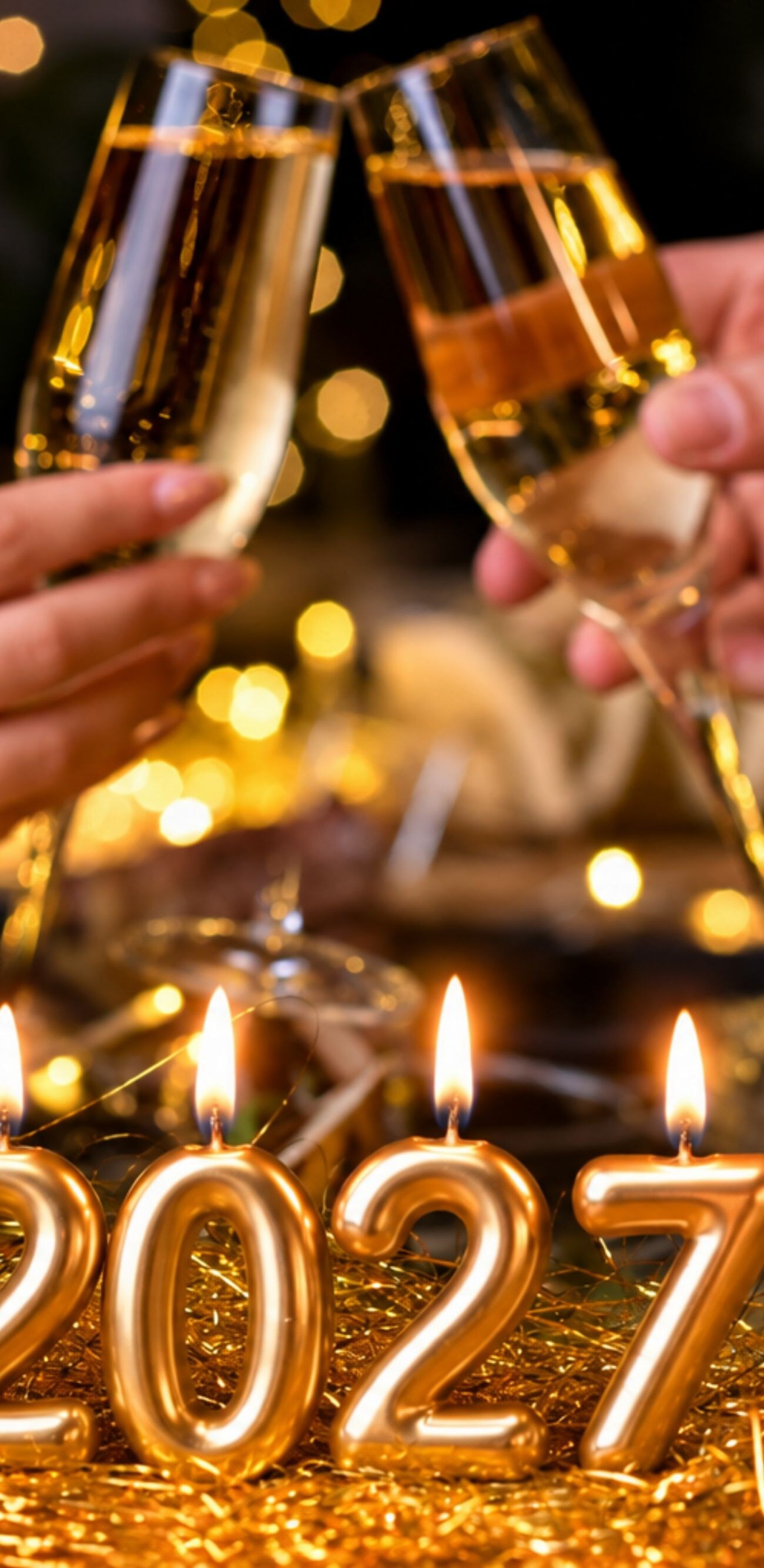 Two people toast beside 2027 candles