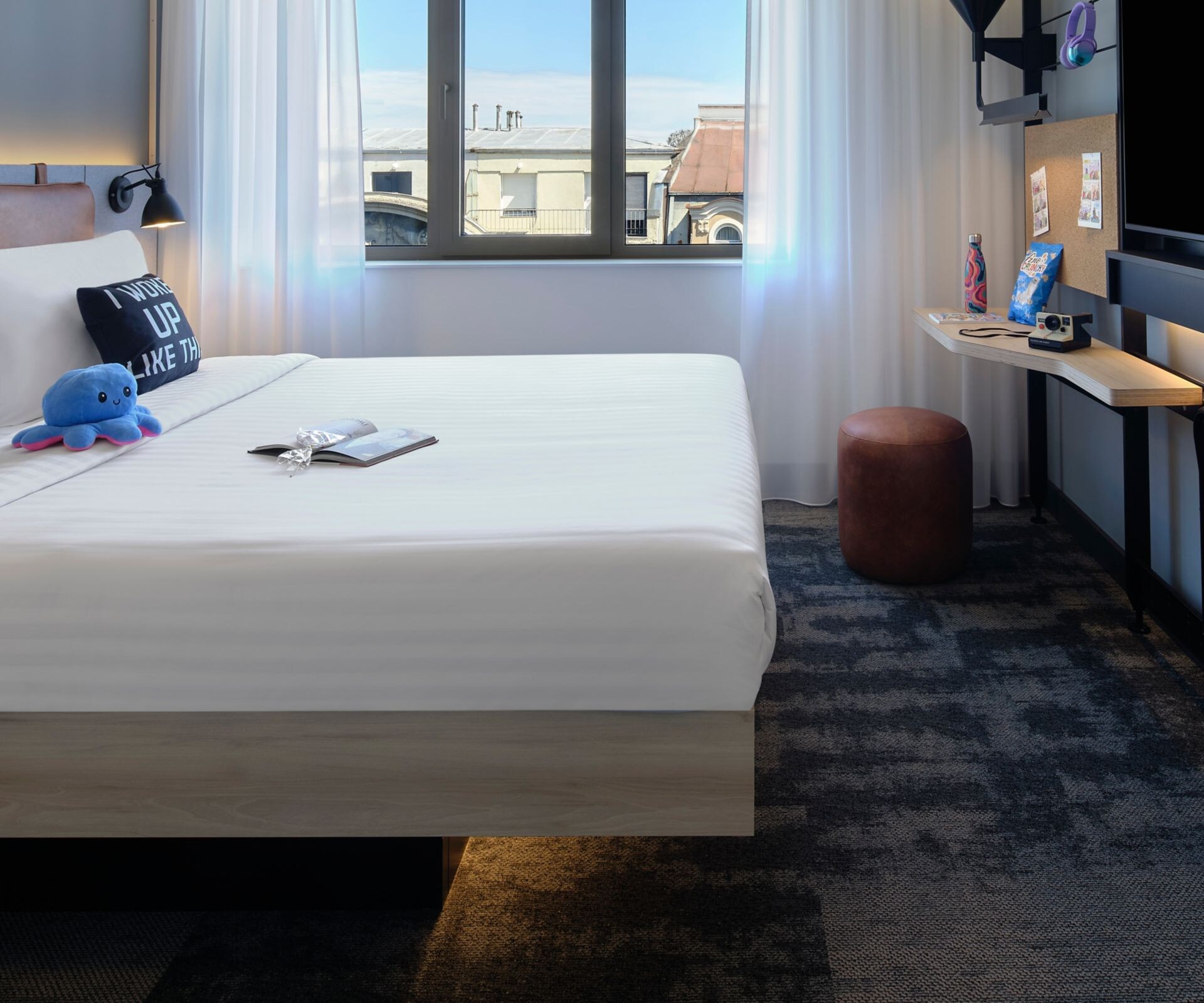 Guest room with a queen bed, TV and folding desk