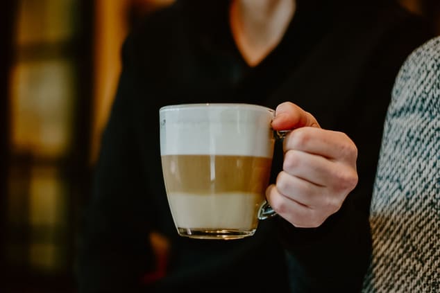Person holding a hot latte