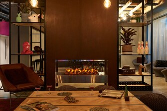 fireplace behind a dark leather chair and table
