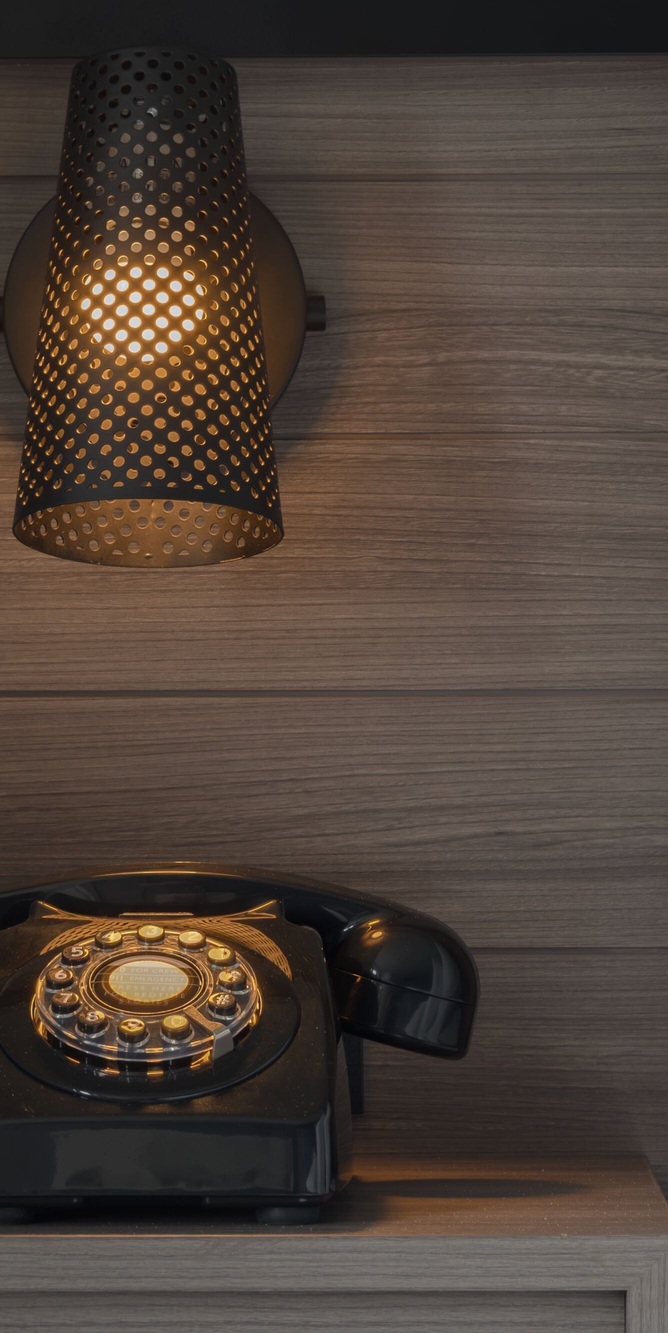 A rotary style phone on a nightstand with light.