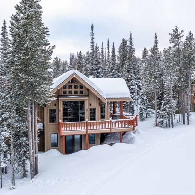 Mountain cabin surrounded by snow and trees