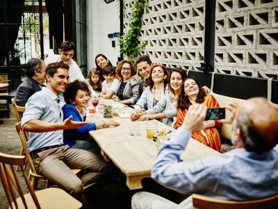 Man taking a family portrait in a restaurant. 