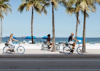 Friends bike riding around a beach in Miami. 