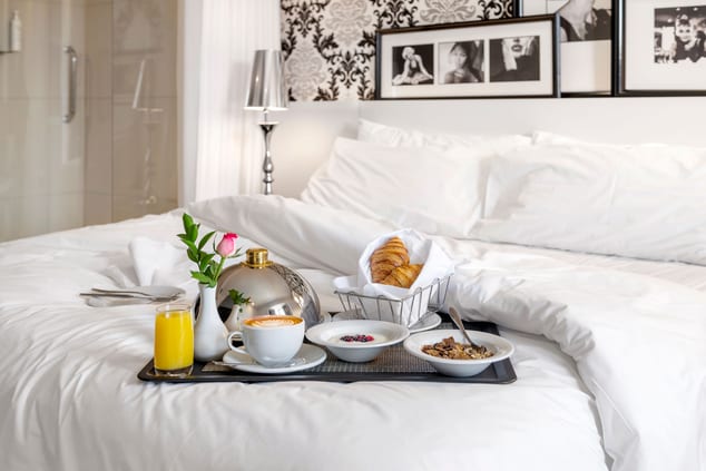 tray of breakfast foods on bed