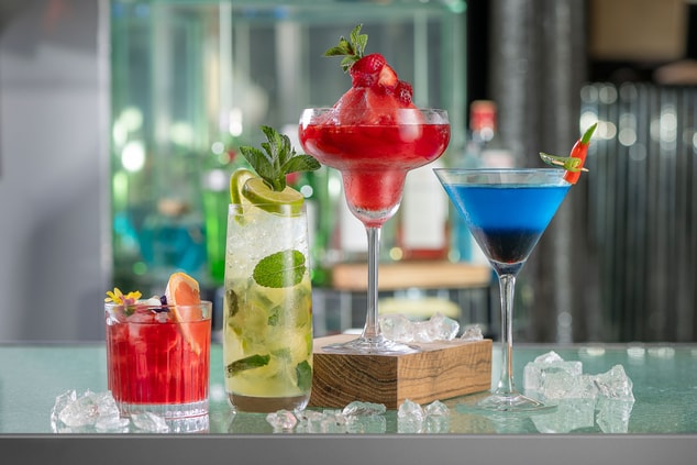 multiple colorful cocktails on bar