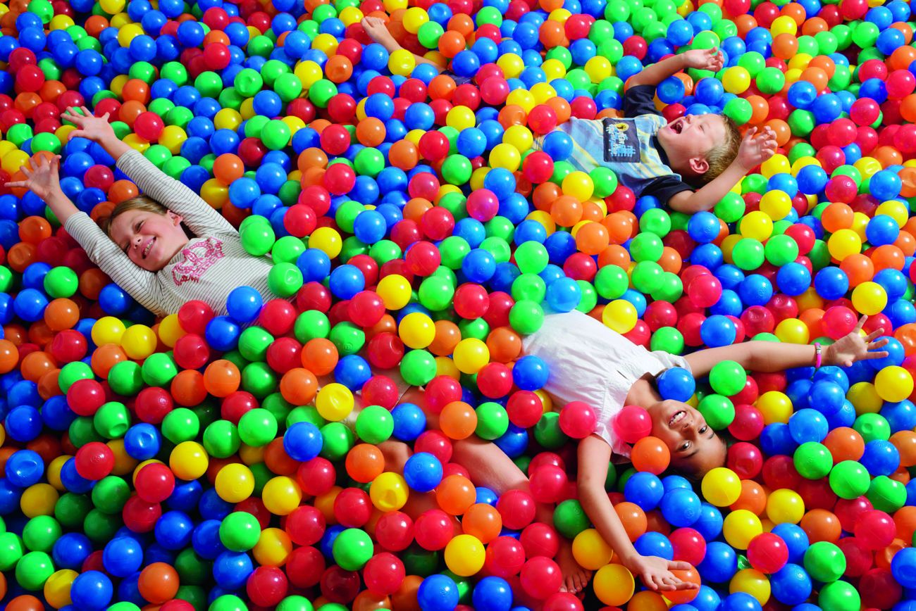 Kids playing in a large pit of colorful, plastic balls