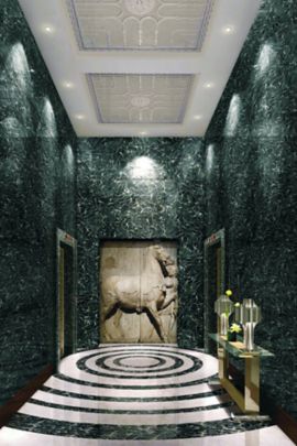 An elevator foyer with marble floors and a large horse wall carving