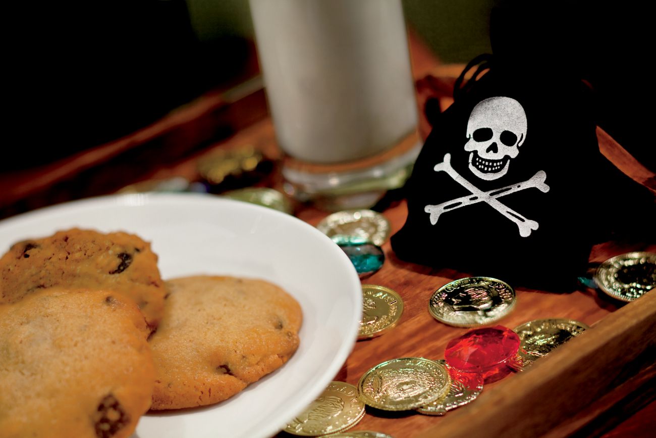 A tray with cookies and milk and pirate-inspired toys