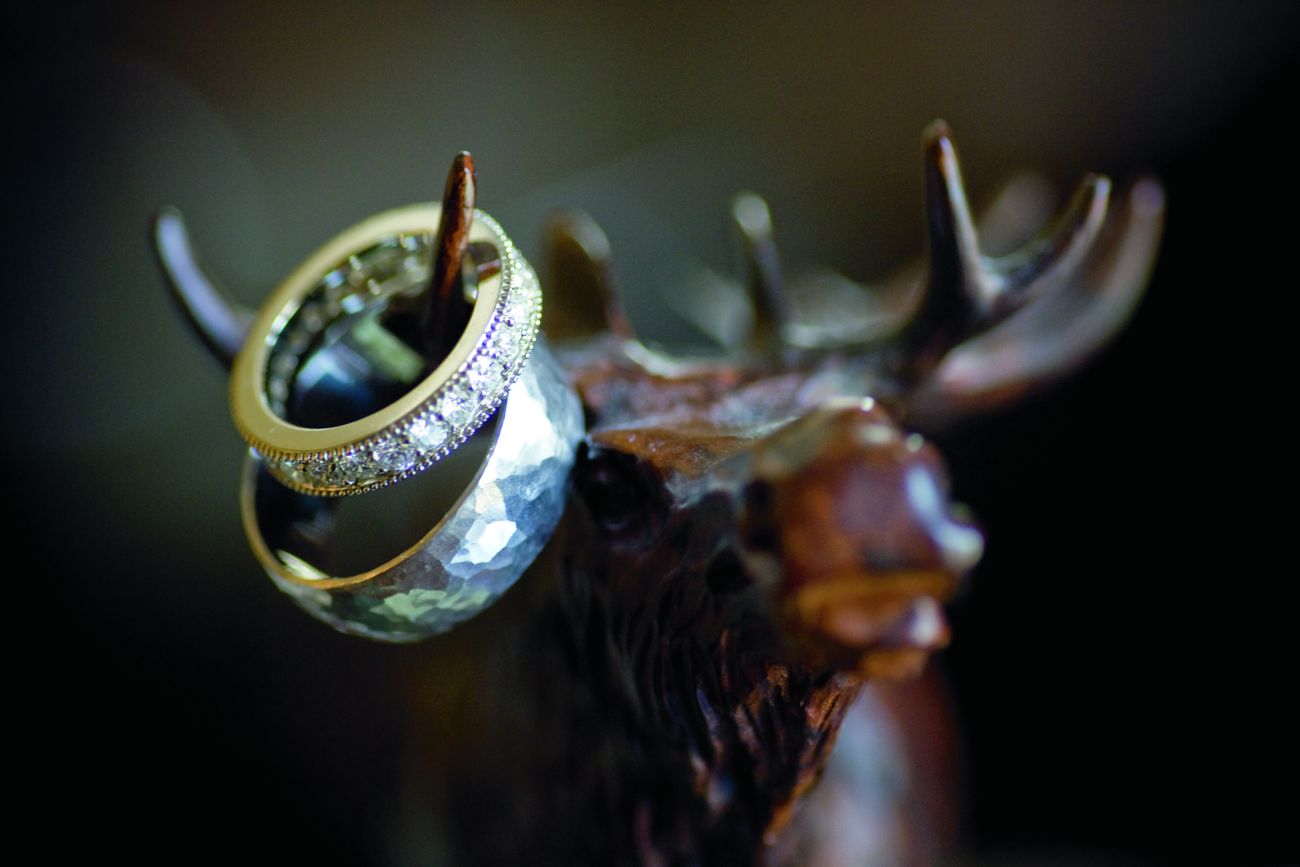 A moose figurine with two wedding rings on a horm
