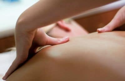 Close-up of a woman receiving a shoulder massage