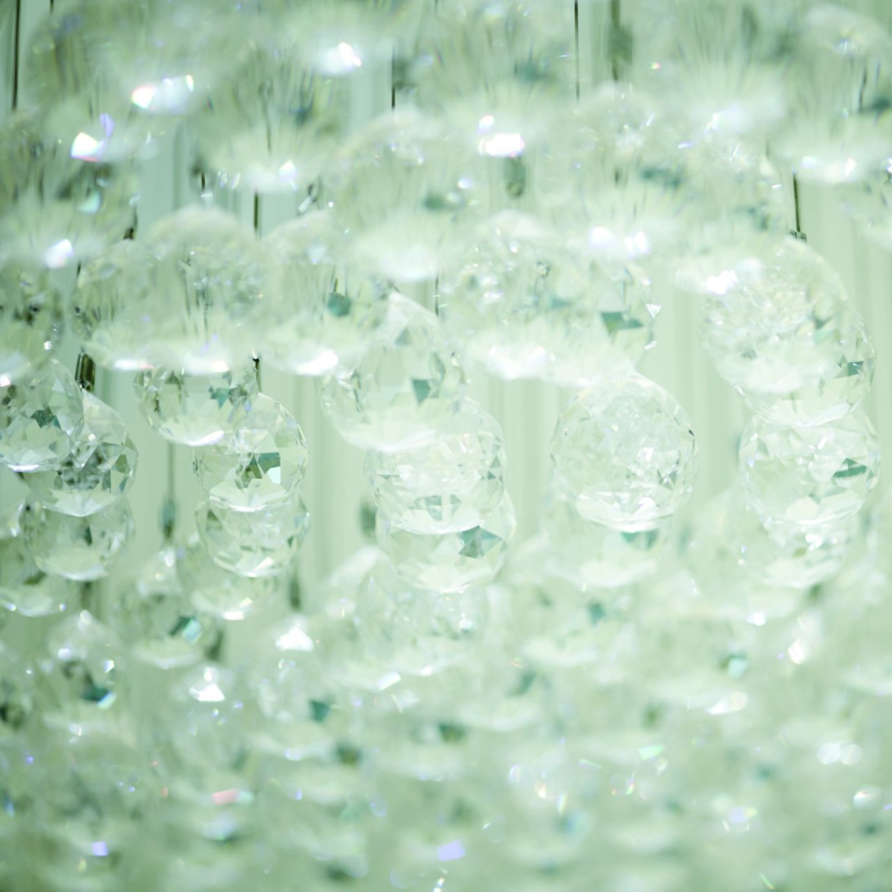 Close-up view of glass spheres bunched closely together with hues of white and sea green