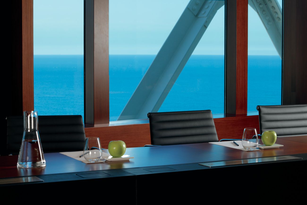 Una sala de reuniones con vistas al mar y sillas a lo largo de una mesa