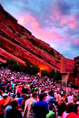 Concert-goers enjoy the sunset show at the outdoor Red Rocks Amphitheatre