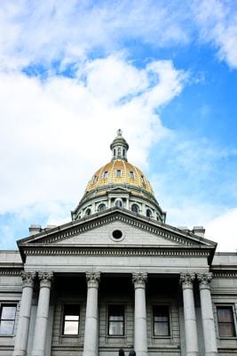 The dramatic entrance of the Colorado State Capitol Building with Corinthian columns and a gold-plated dome