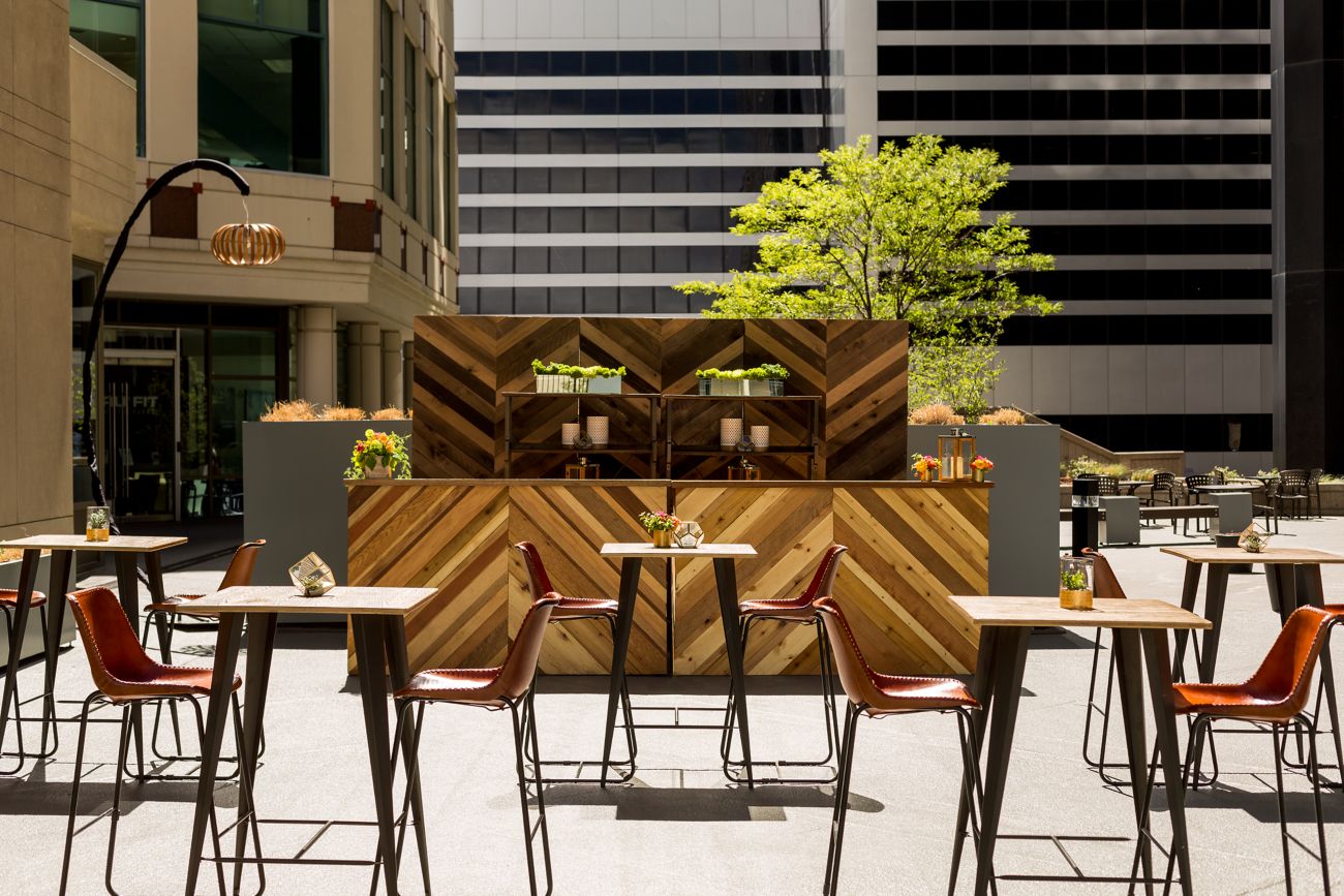 A bar and cocktail tables set up on a terrace
