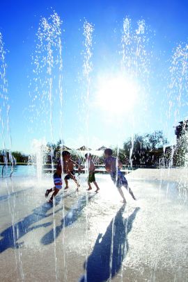 Kids jumping around in the fountain jets of a splash pad at the resort