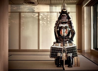 Ancient samurai armor assembled in a spare, Japanese-style room with screen walls
