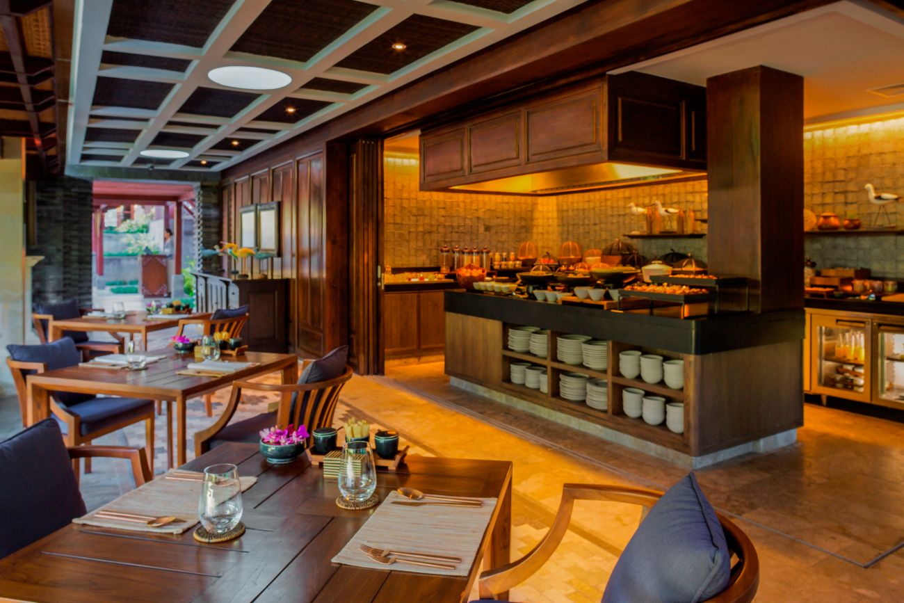 Breakfast buffet setup in an alcove with four-top tables lined up along the main floor