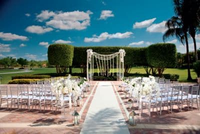 Bright white dominates the wedding décor, from the whimsical outdoor altar to the grand floral arrangements