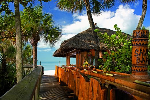 An outdoor bar leads up to the palapa that houses Sand Bar, with the ocean just beyond