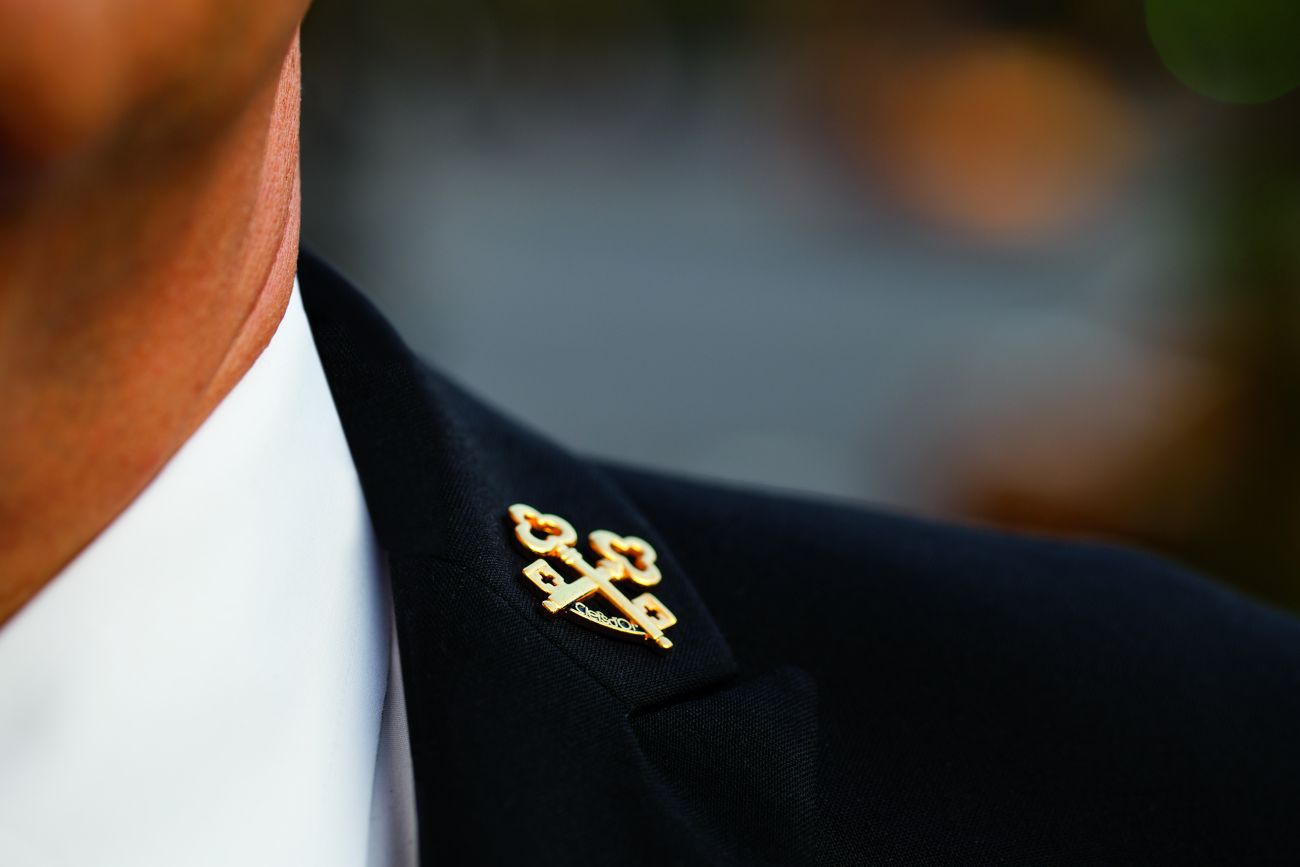 Lapel pin on an immaculate black coat featuring the crossed keys of Les Clefs D?Or