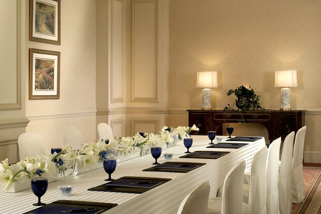 花のセンターピースが飾られた、部屋のほぼ全長に及ぶ長いテーブル