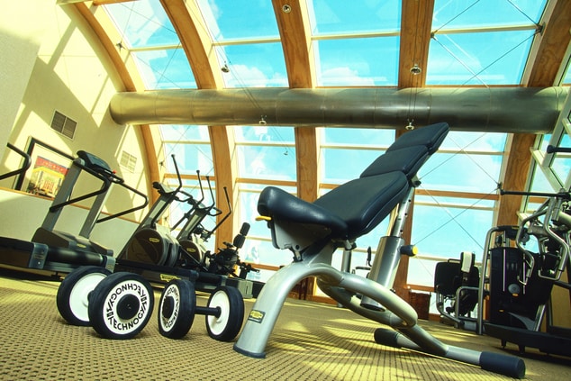 A room with fitness equipment and a curved glass roof