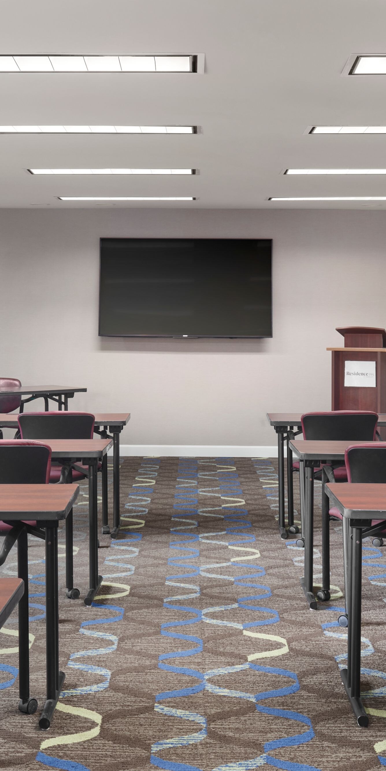 Meeting room with tables, chairs and screen