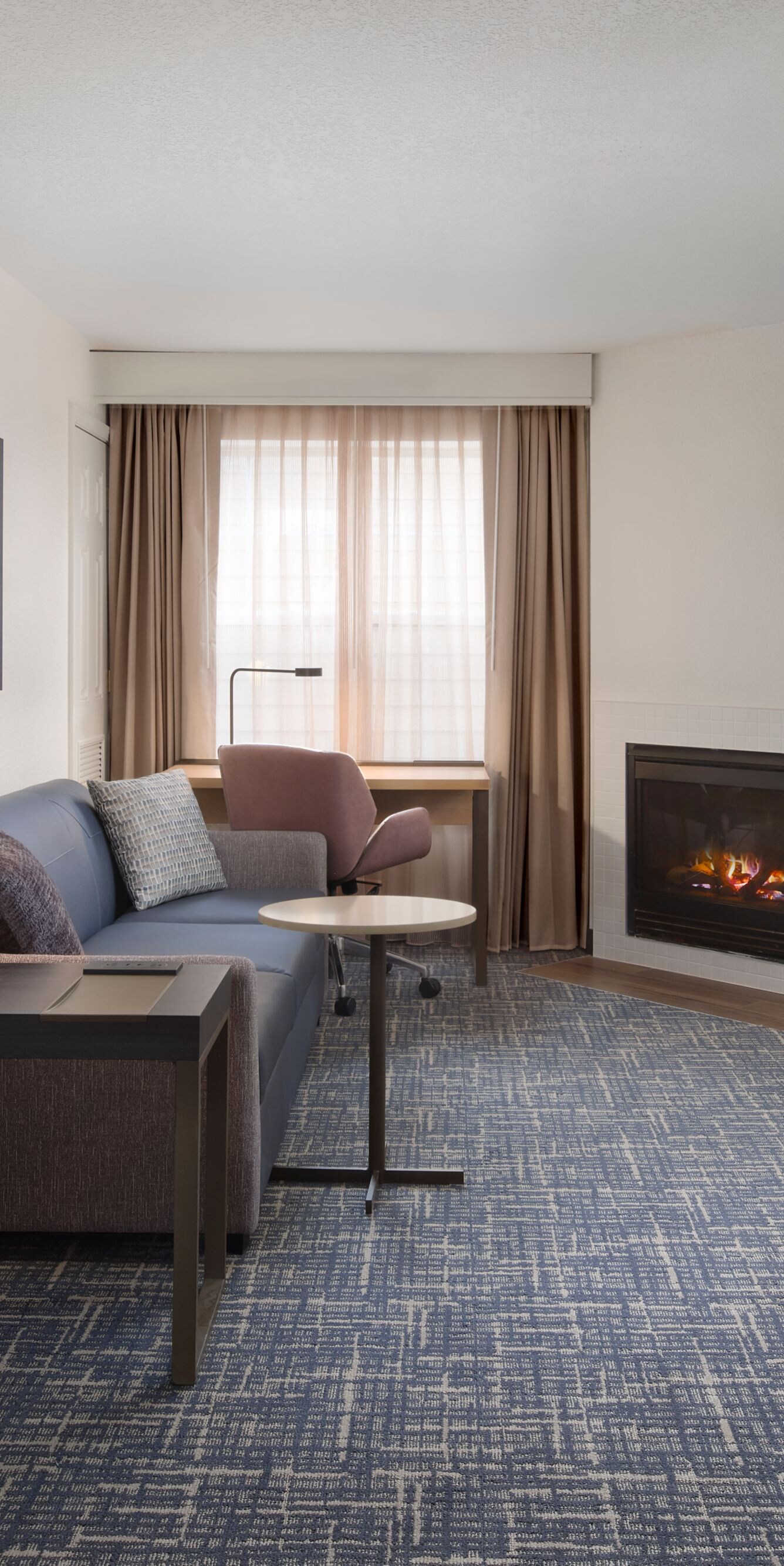 Open suite living area with fireplace and TV