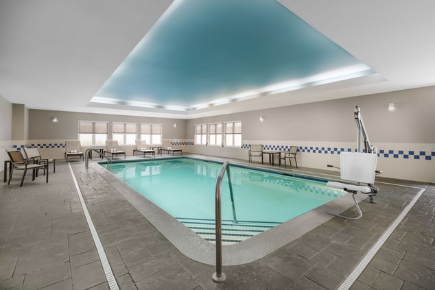 Indoor pool with chair lift and lounge chairs
