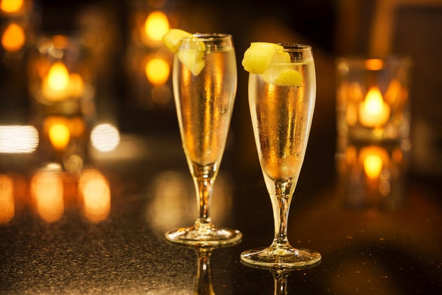 Two cocktails in champagne glasses with lemon