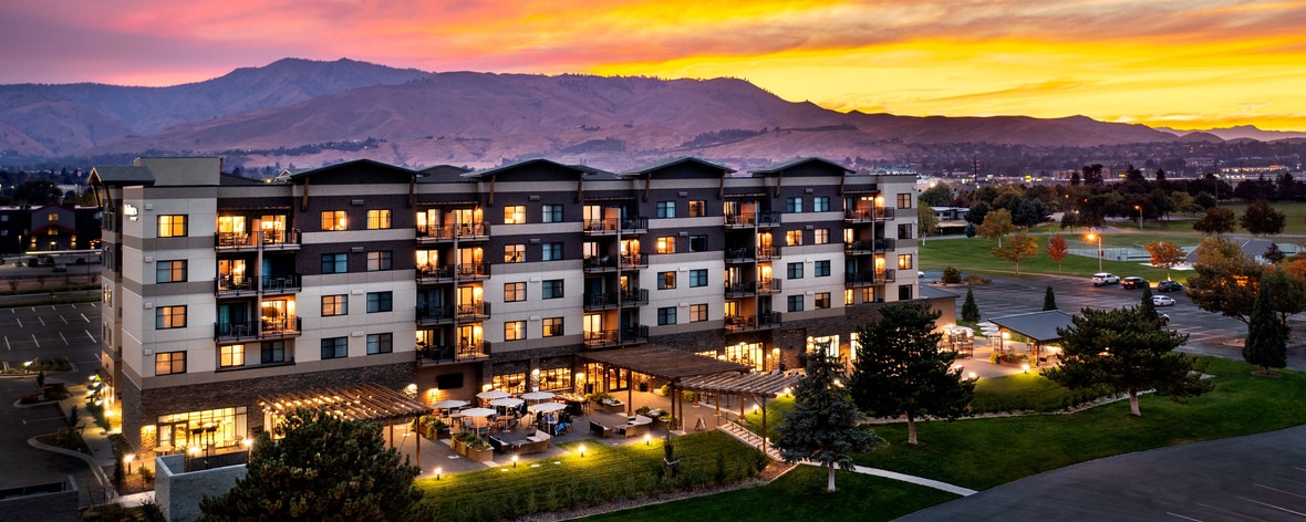 sunrise photo of hotel with patio and mountains