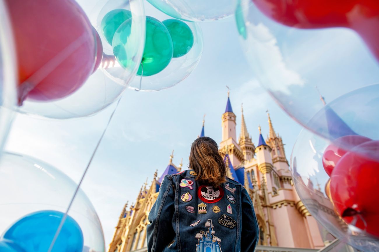 A woman is standing in front of Cinderella Castle.