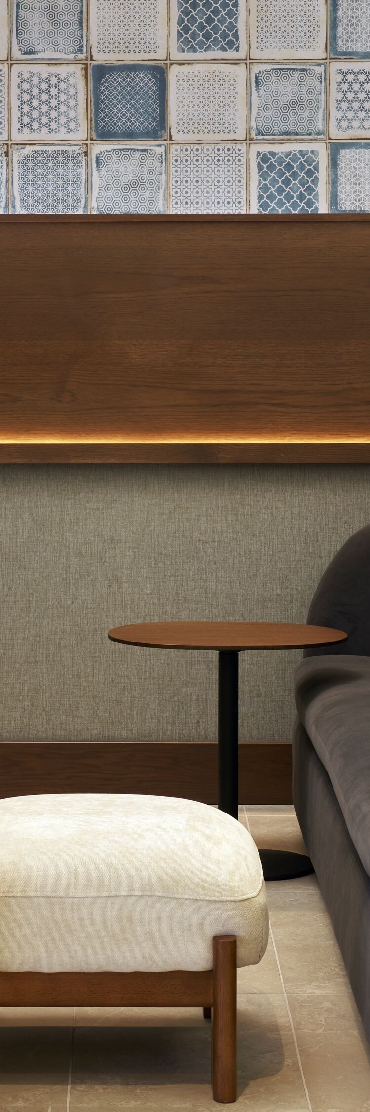 small booth with couch, ottoman, and tv