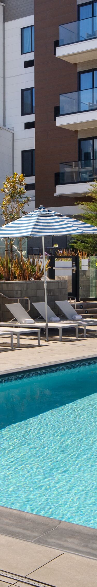 Outdoor pool with lounge chairs and building