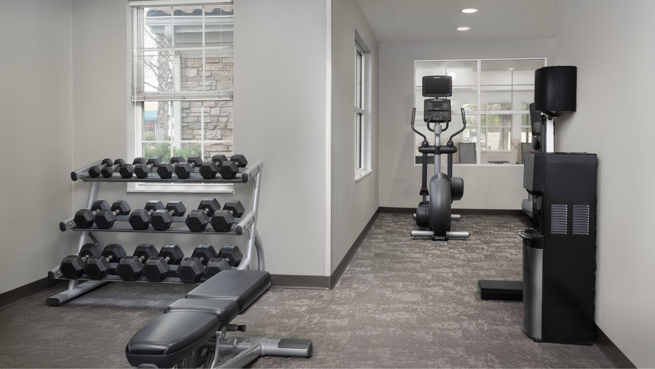 fitness room with weights and eliptical machine
