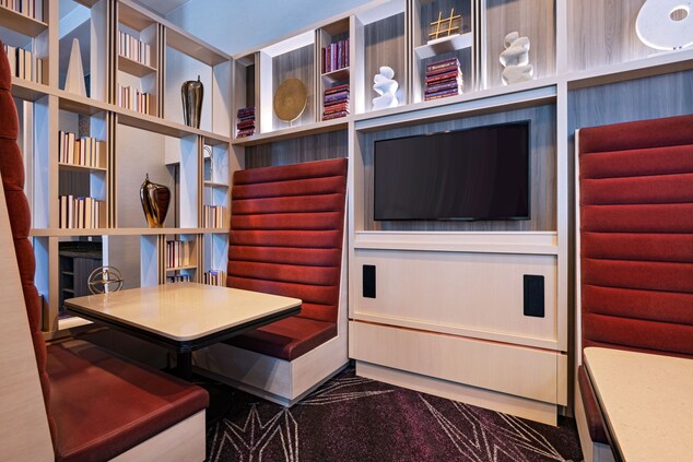 Booth seating, television, bookshelf, table