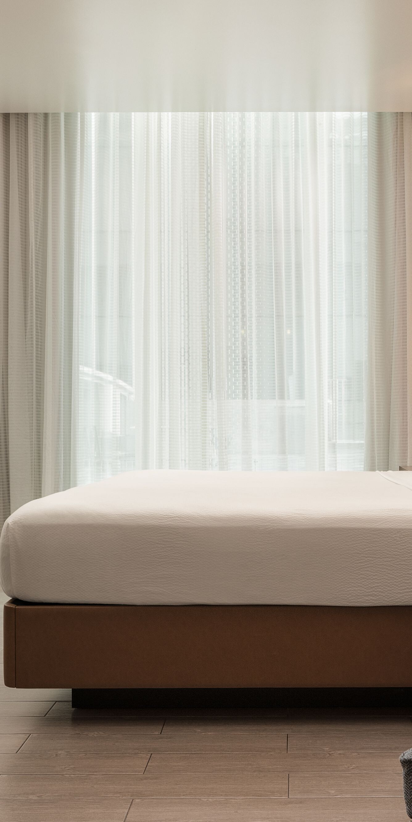 Cama tamaño King, sillón, armario y ventanas