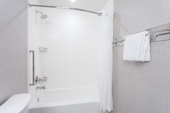 Bañera grande con cortina para ducha.