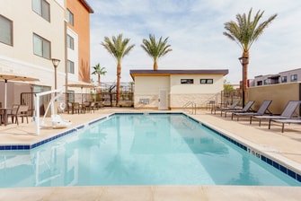 Vista soleada de la piscina al aire libre y las palmeras.