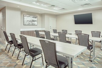 Sala de reuniones con filas de mesas y sillas