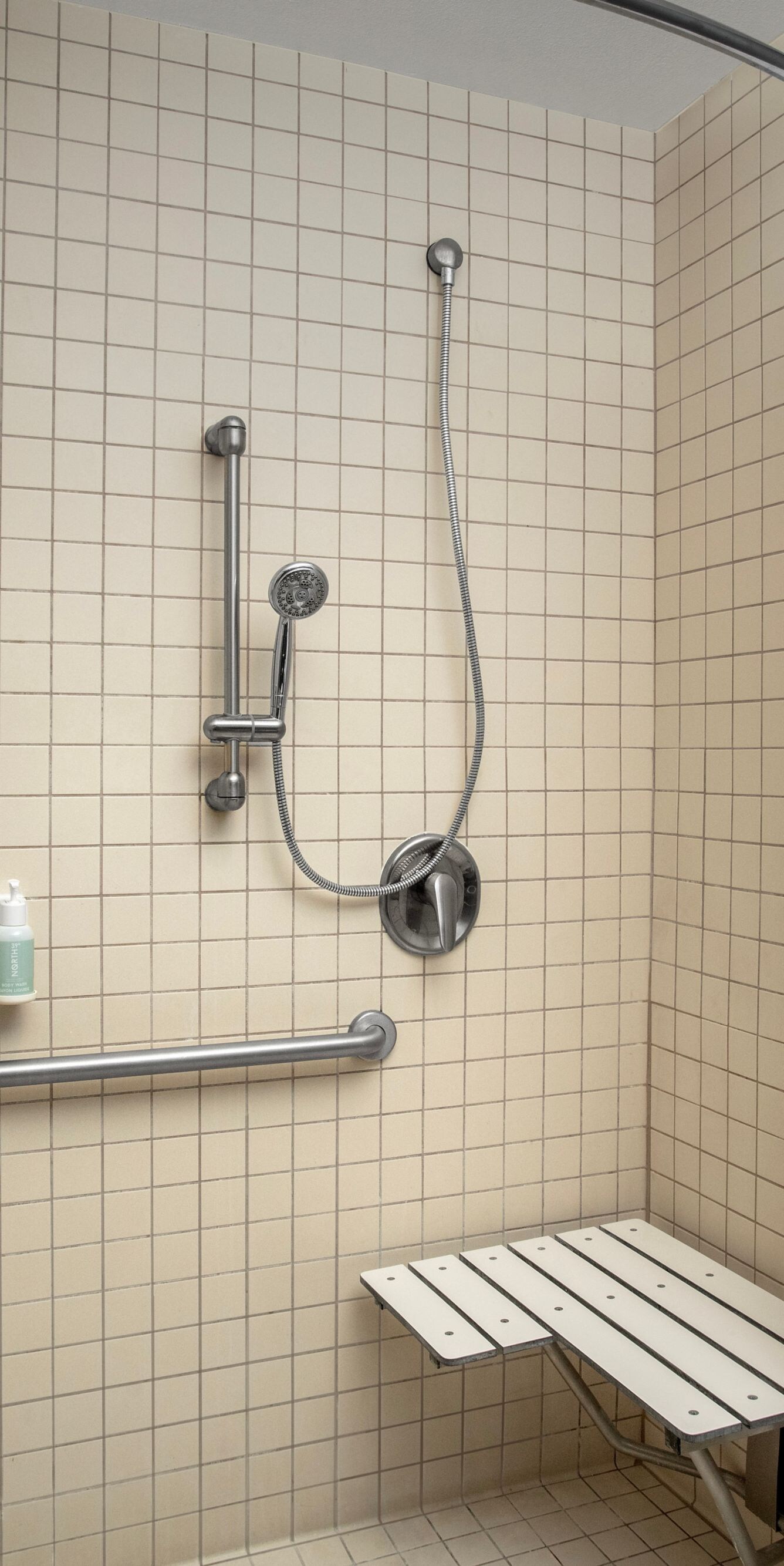 Accessible roll-in shower with grab bars and seat