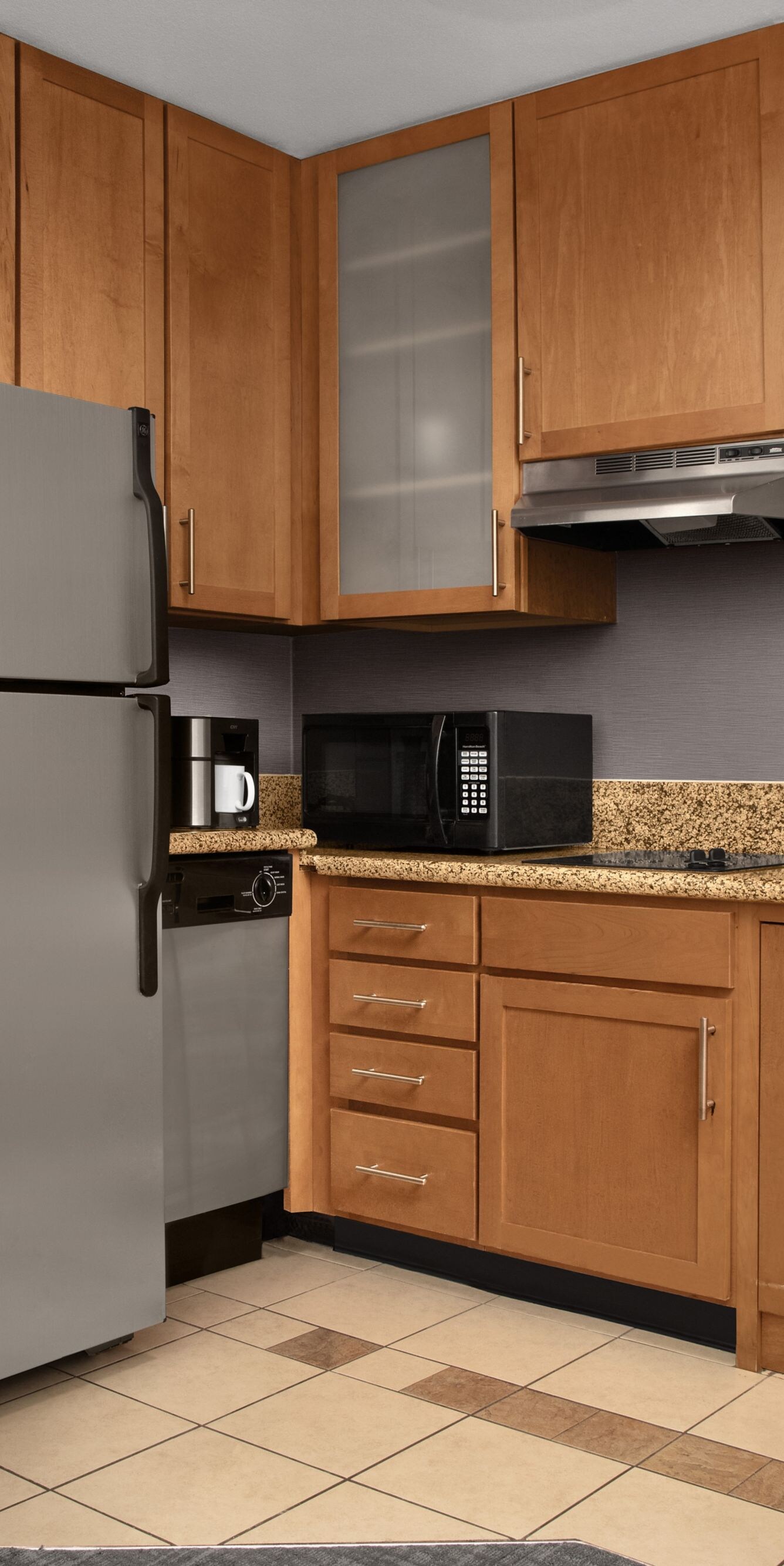 One-bedroom suite kitchen with fridge and cabinets
