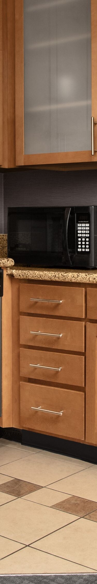 One-bedroom suite kitchen with fridge and cabinets