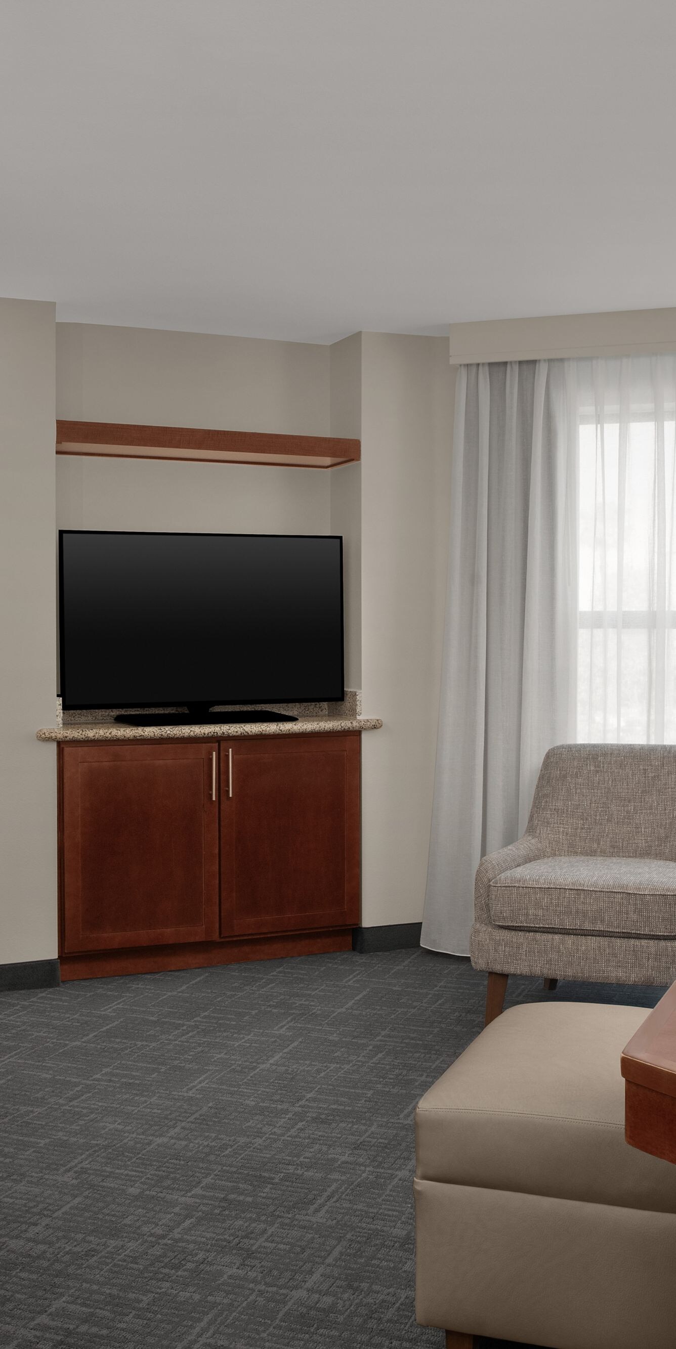 One-bedroom suite living area with sofa and TV