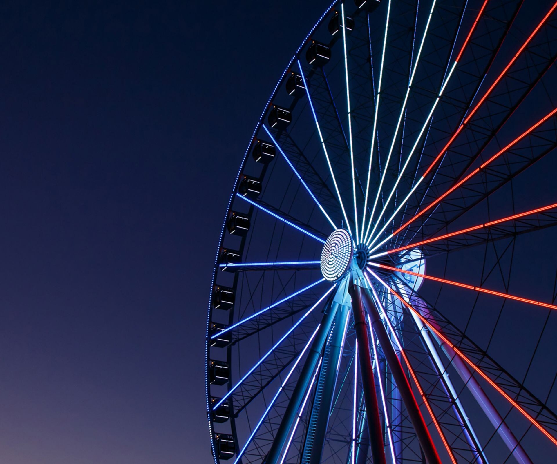 Illuminated ferris wheel with sunset