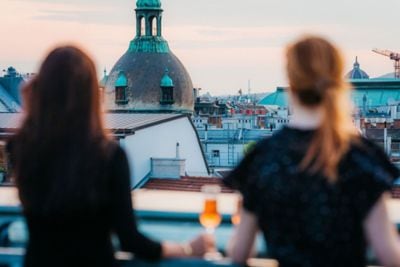 Two women stand on a patio overlooking Vienna.